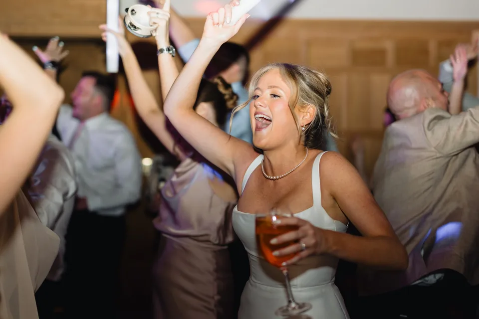 Bride celebrating with guests on the wedding dance floor
