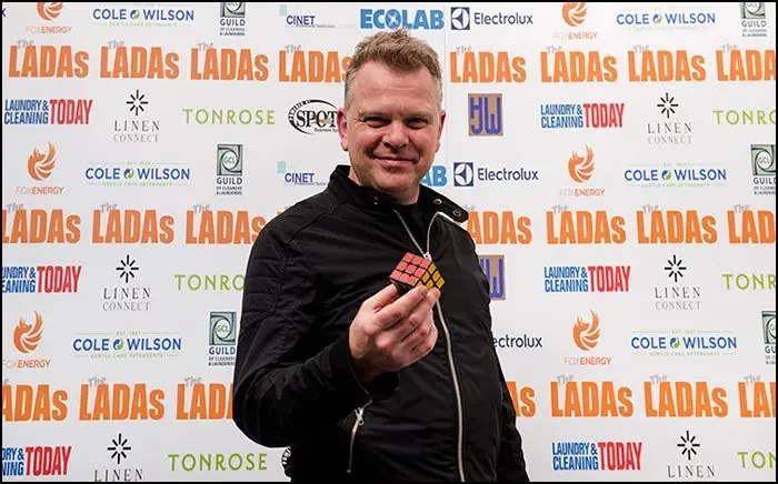 Magician Collin Claus holding a Rubik’s cube at an event