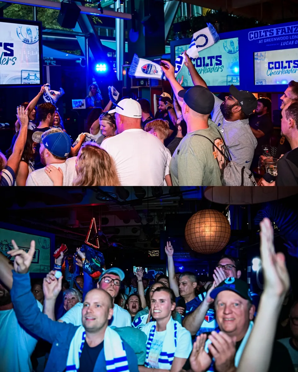 Colts supporters raising scarves and cheering at Greenwood