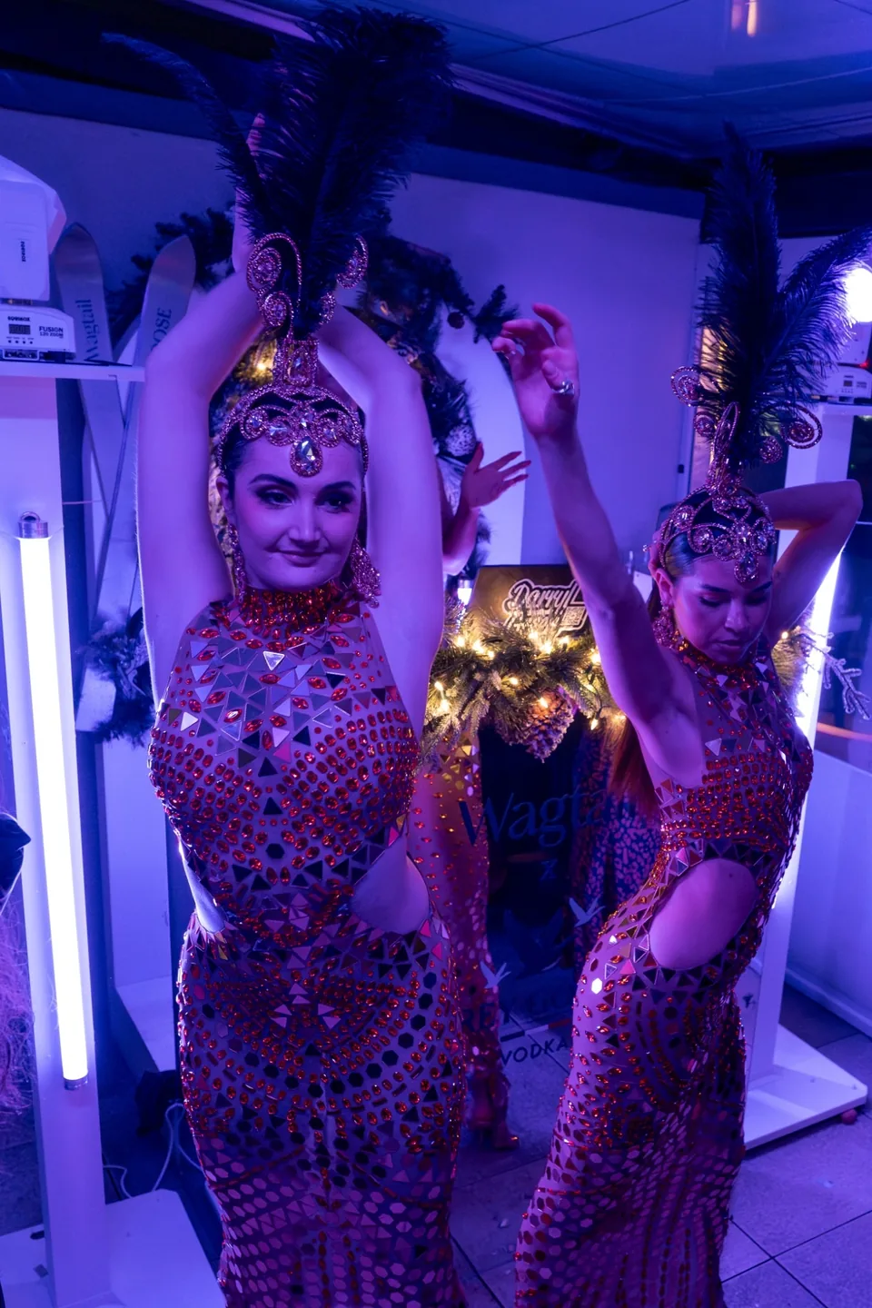 Glamorous dancers wearing embellished costumes and feathered headpieces