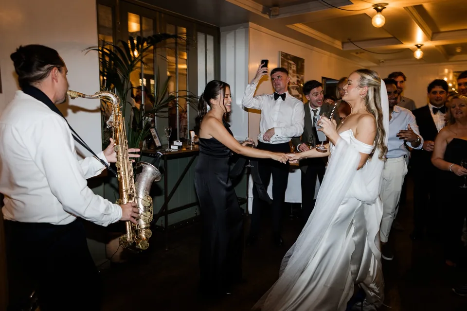 Bride dancing beside the live saxophonist at The Italian Greyhound