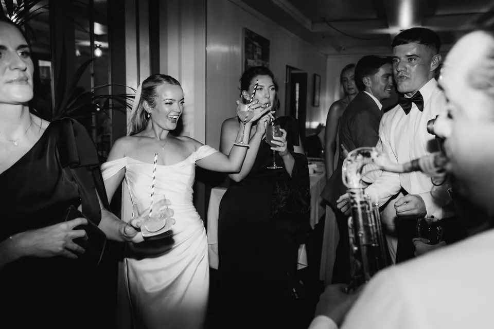 Wedding guests gathered around the live saxophonist at The Italian Greyhound