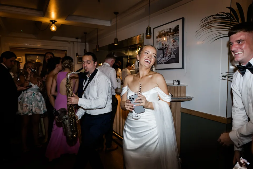 Bride celebrating with a live saxophonist at The Italian Greyhound in London