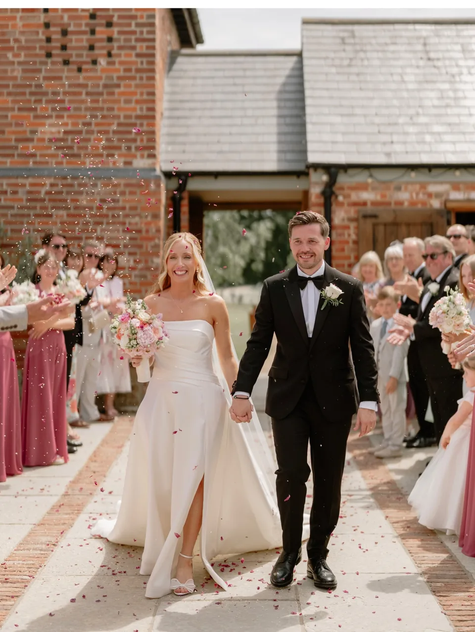 Newly married couple celebrating outside Apton Hall in Rochford, Essex