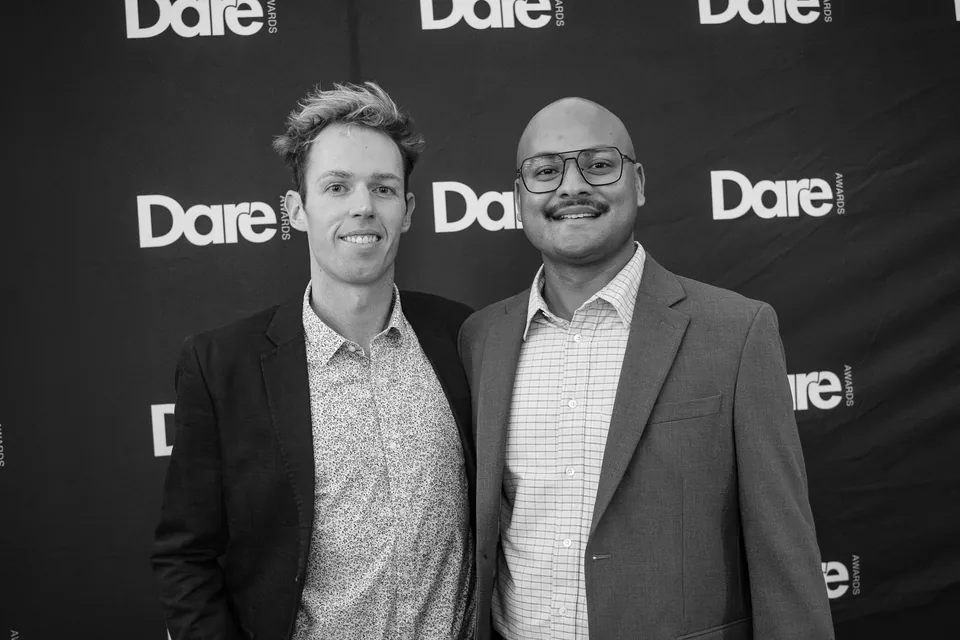 Black-and-white portrait of two guests in front of the event backdrop at Wagtail